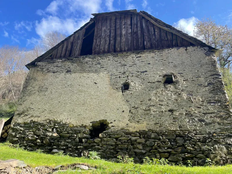 Grange en pierre ancienne avec toiture à charpente bois apparente