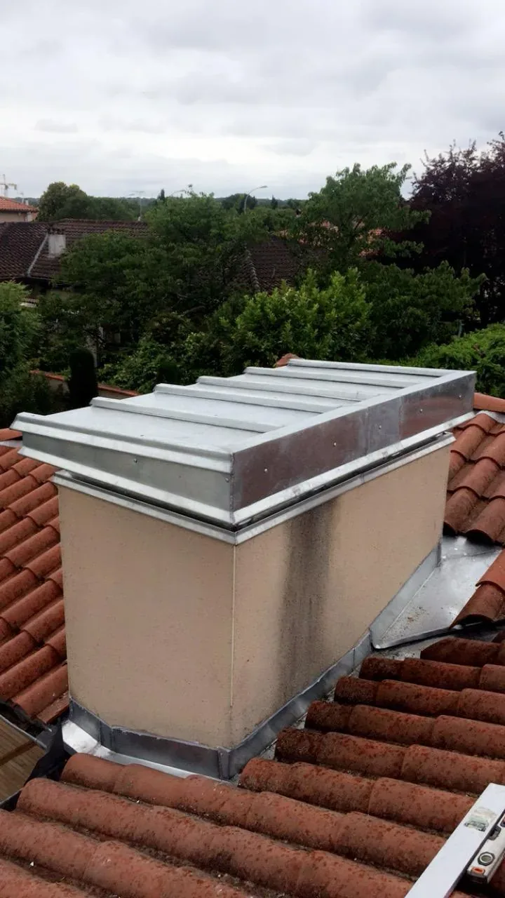Souche de cheminée habillée de zinc neuf, vue depuis la toiture